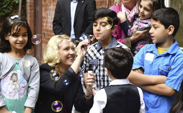 La ministra de Familia alemana, Manuela Schwesig (2-i), juega con varios niños en un centro para refugiados en Berlín.