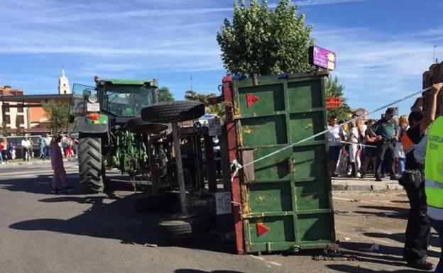 El remolque del tractor, volcado en la vía. 