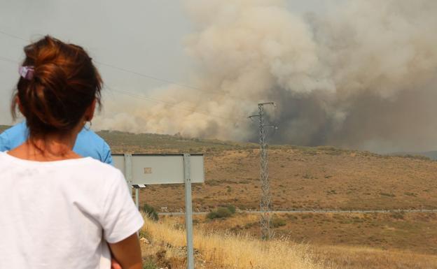 Unos vecinos miran con preocupación el incendio de La Cabrera.