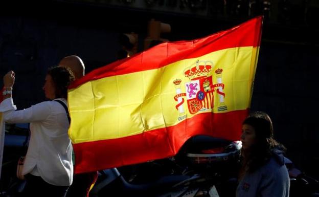 Una mujer porta una bandera de España.