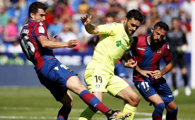 El delantero del Getafe Jorge Molina (c) disputa un balón con los jugadores del Levante Sergio Postigo (i) y José Luis Morales (d)