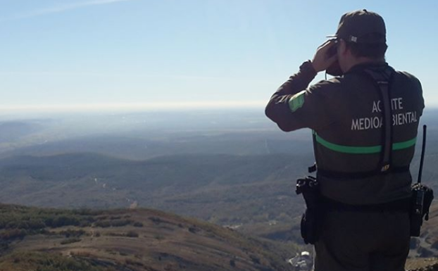 Un agente Medioambiental divisando un monte 