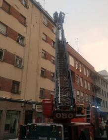Imagen secundaria 2 - Los Bomberos cortan la calle López de Fenar para poder retirar placas de hielo de los tejados