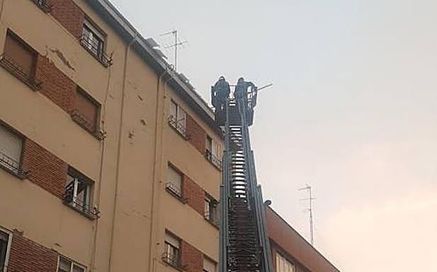 Imagen principal - Los Bomberos cortan la calle López de Fenar para poder retirar placas de hielo de los tejados