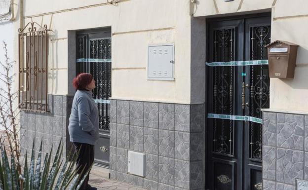 Una mujer observa la vivienda en la que la mujer fe asesinada.