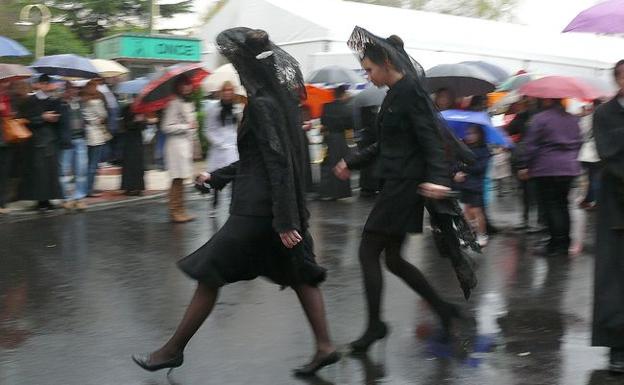 Dos manolas intentan escapar de la lluvia. 