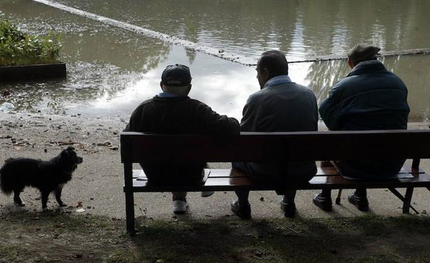 Jubilados descansan en el banco de un parque. 