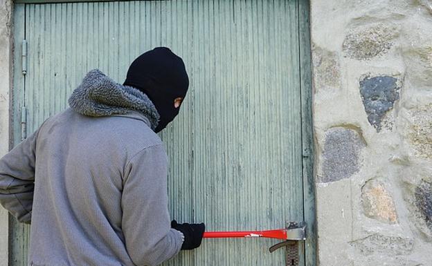 Un ladrón intenta forzar una puerta.