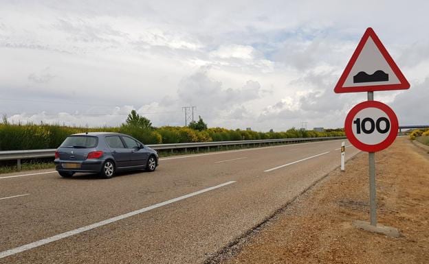 Imagen de una señal de 100 kilómetros por hora mientras los vehículos circulan por la izquierda.
