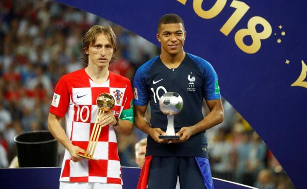 Modric (Balón de Oro) y Mbappé (mejor joven) posan con sus trofeos. 