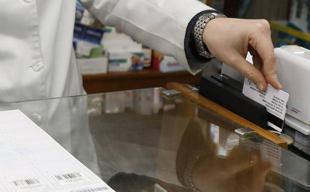 Una farmacéutica pasa la receta electrónica