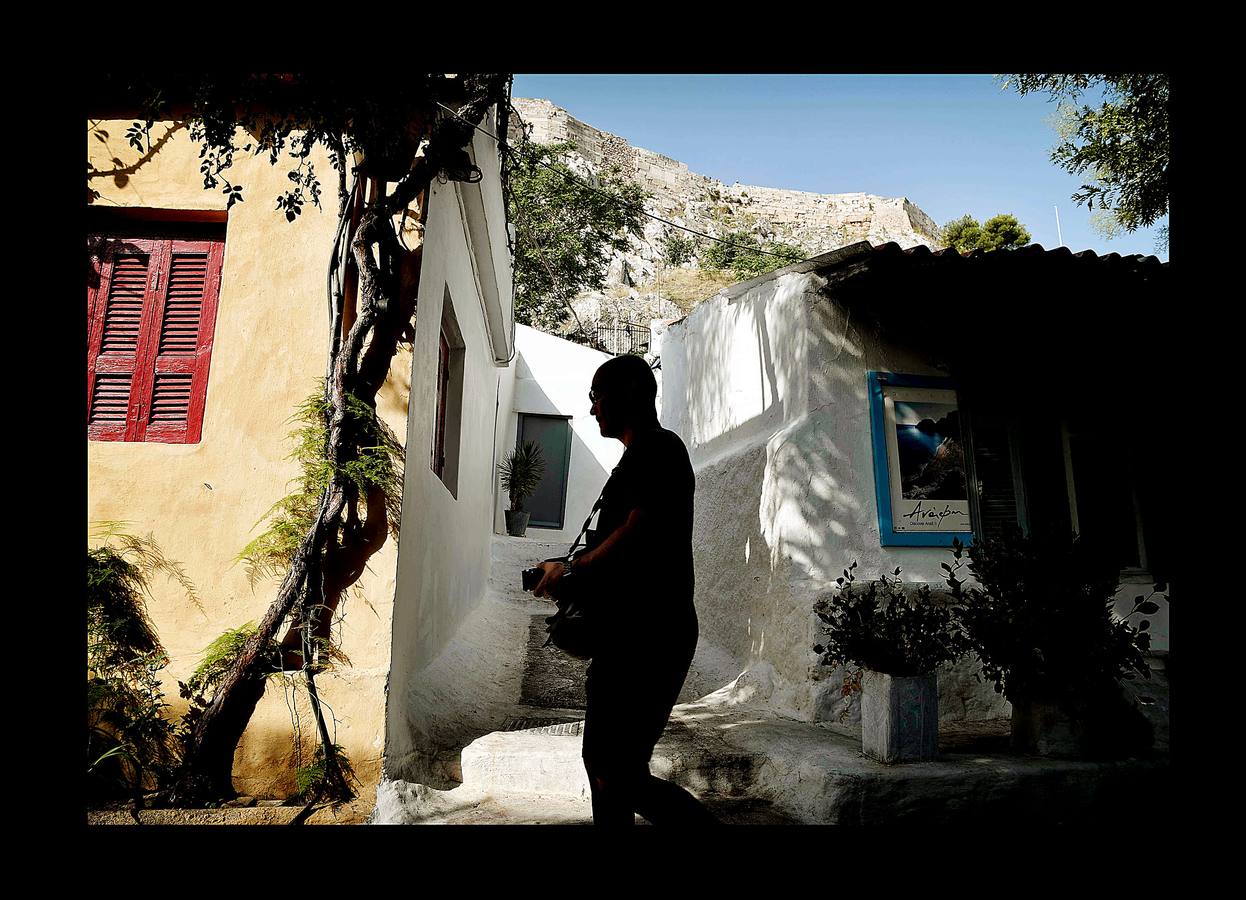 El distrito de Anafiotika, en Atenas, tiene el aire de un pintoresco pueblo de piedra sacado de las islas Cícladas, pero se encuentra a los pies de la Acrópolis. Quien ascienda por las estrechas y sinuosas calles del distrito de Plaka se sorprenderá ante la vista de un pueblo casi idéntico a los de las islas del mar Egeo. De hecho, las cien casas con techos de tejas, conocidas como Anafiotika, son tan antiguas como la capital griega moderna. Y es que para devolver a la ciudad su gloria clásica tras la guerra contra el imperio Otomano, el rey de Grecia invitó a los mejores canteros de la isla egea de Anafi a trabajar en su reconstrucción.