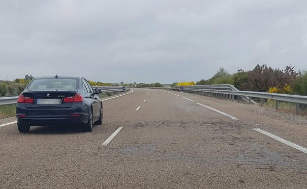 Un vehículo circula por el carril izquierdo ante el pésimo estado del firme en la zona derecha.