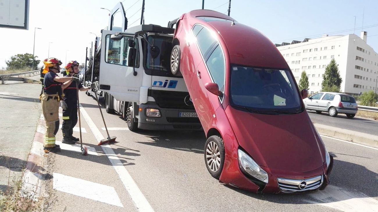 Un coche se cae de un camión portavehículos en un semáforo de la avenida de Madrid, en Valladolid