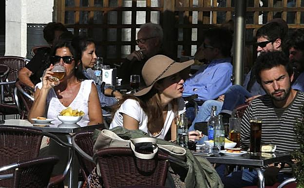 Clientes disfrutan del veranillo de San Martín en una terraza, el año pasado.