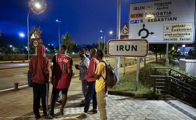 Varios migrantes esperan a la entrada de Irún. 