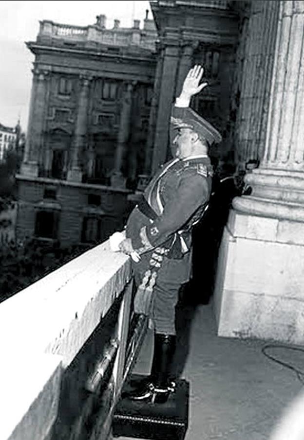 Franco, subido a un escabel, saluda a la multitud desde una balconada del Palacio de Oriente. 