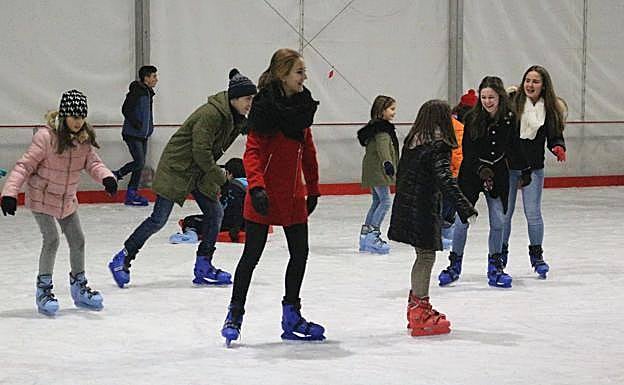 Niños disfrutan de una pista de hielo.