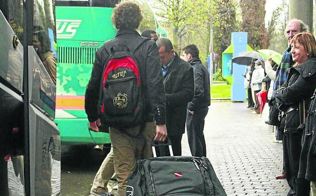 Jóvenes con maletas en una estación de autobuses. 