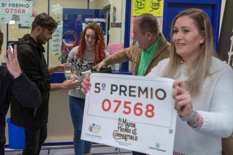 Rocío Romero, hija del dueño de la administración de loterías del centro comercial Leclerc de Ciudad Real que ha vendido 15 series del número 07568, el segundo de los quintos premios del sorteo extraordinario de Navidad con lo que ha repartido cerca de 900.000 euros en premios, posa con el número agraciado.
