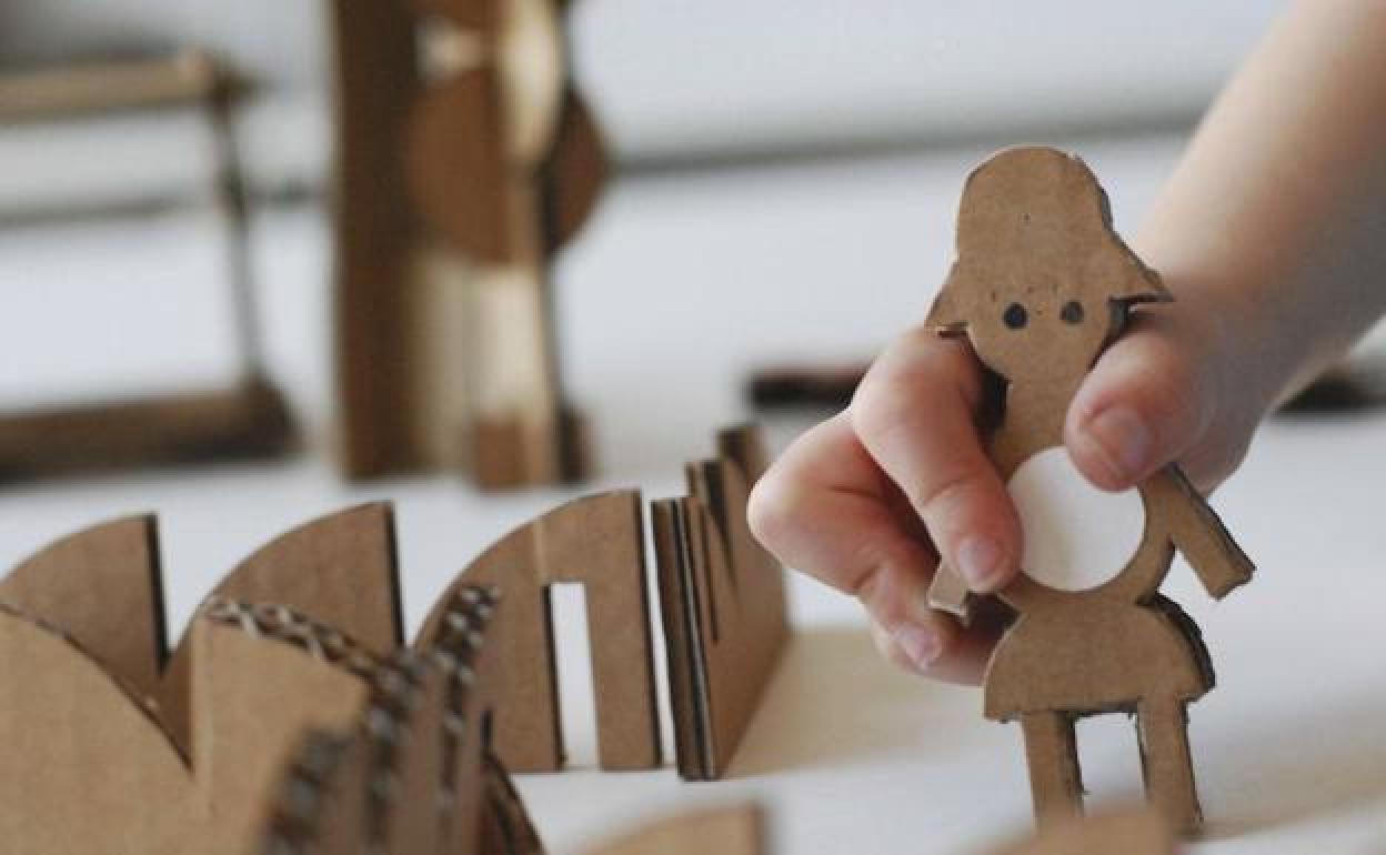 Un niño juega con una figura de cartón. 