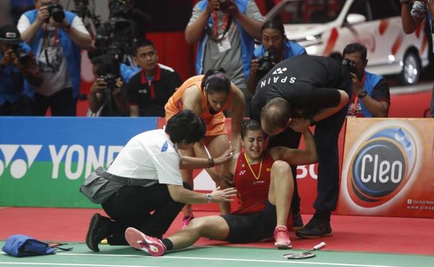 Carolina Marín siendo ayudada a levantarse tras un mal apoyo en la final del Masters de Indonesia