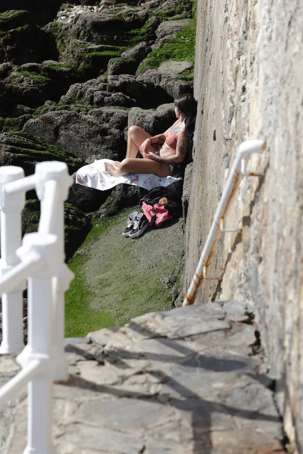 Decenas de personas se animaron a pasear por la Playa de San Lorenzo, bajo el sol y por la gran extensión de arena que dejó la bajamar