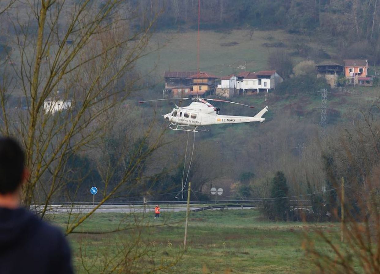 Recuperan el helicóptero de la BRIF de Tabuyo que cayó al río Narcea en Belmonte cuando trabaja en la extinción de un incendio forestal | Ha sido izado por otra aeronave, que lo ha depositado en tierra, donde se trabaja en el desmontaje de las hélices para su evacuación