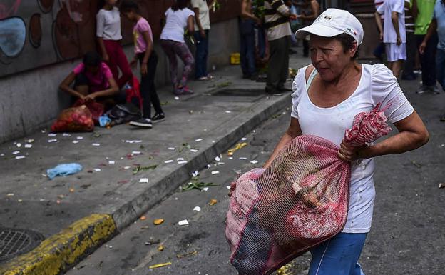 Una mujer lleva una bolsa con comida en Venezuela. 