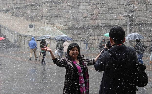 Una pareja de turistas se hace una fotografía junto al acueducto de Segovia en la mañana de este viernes.