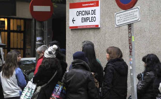 Parados haciendo cola en una oficina de empleo. 