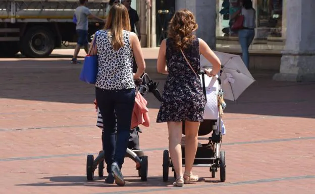 Dos mujeres pasean a su hijos.