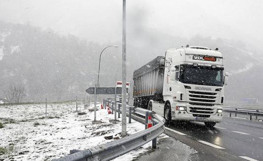 Un camión transita bajo la nieve en el Huerna.
