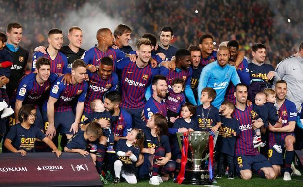 Los jugadores del Barça celebran la vigésimo sexta Liga del Barça con el trofeo.