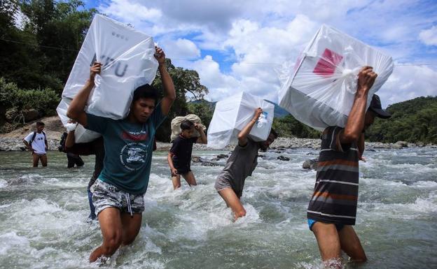 Traslado a hombros de las urnas para distribuirlas entre distintas poblaciones en Indonesia.