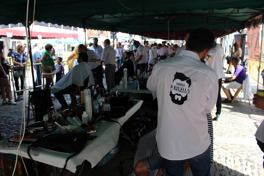 La céntrica plaza de San Marcelo se ha convertido en la jornada del domingo en un improvisado salón de belleza, en el que peluqueros, barberos, tatuadores, maquilladores y masajistas se han puesto a trabajar bajo la iniciativa 'León te corta' promovida por Víctor Valín en favor de la AECC