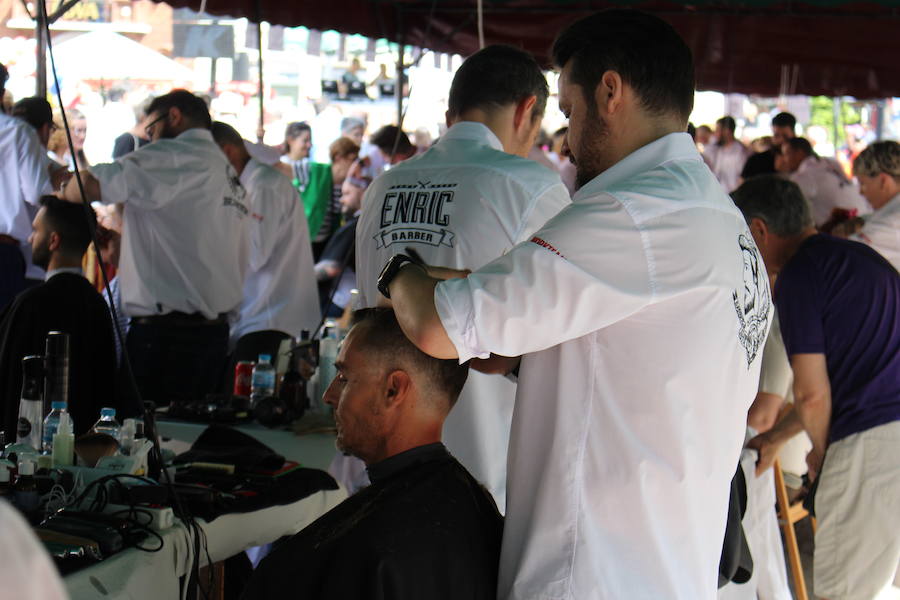 La céntrica plaza de San Marcelo se ha convertido en la jornada del domingo en un improvisado salón de belleza, en el que peluqueros, barberos, tatuadores, maquilladores y masajistas se han puesto a trabajar bajo la iniciativa 'León te corta' promovida por Víctor Valín en favor de la AECC