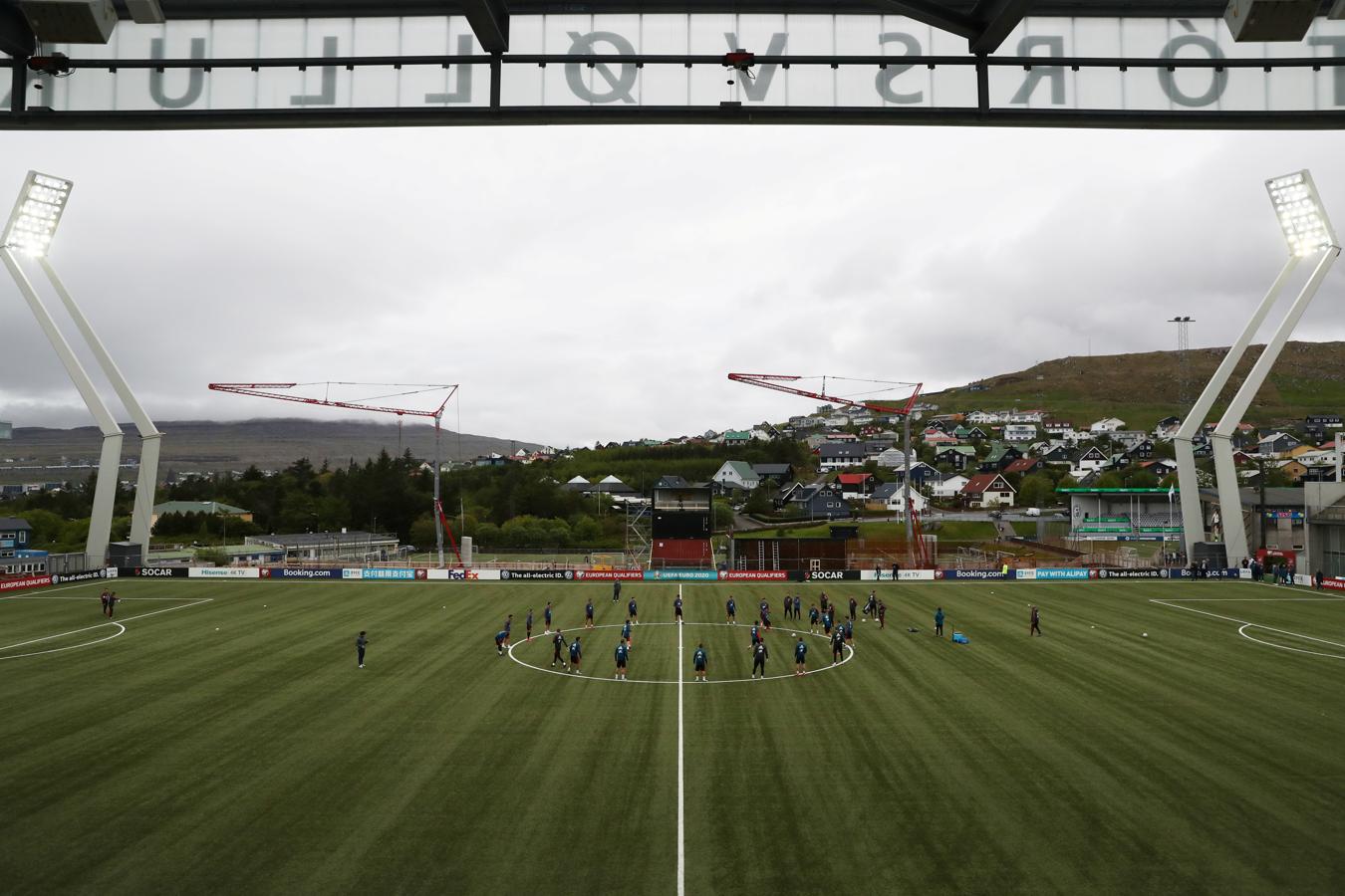 Plano desde la tribuna principal y enfrente, junto a la línea central, se ven los contenedores utilizados para colocar la cámara en el lateral que no hay grada sino varias grúas