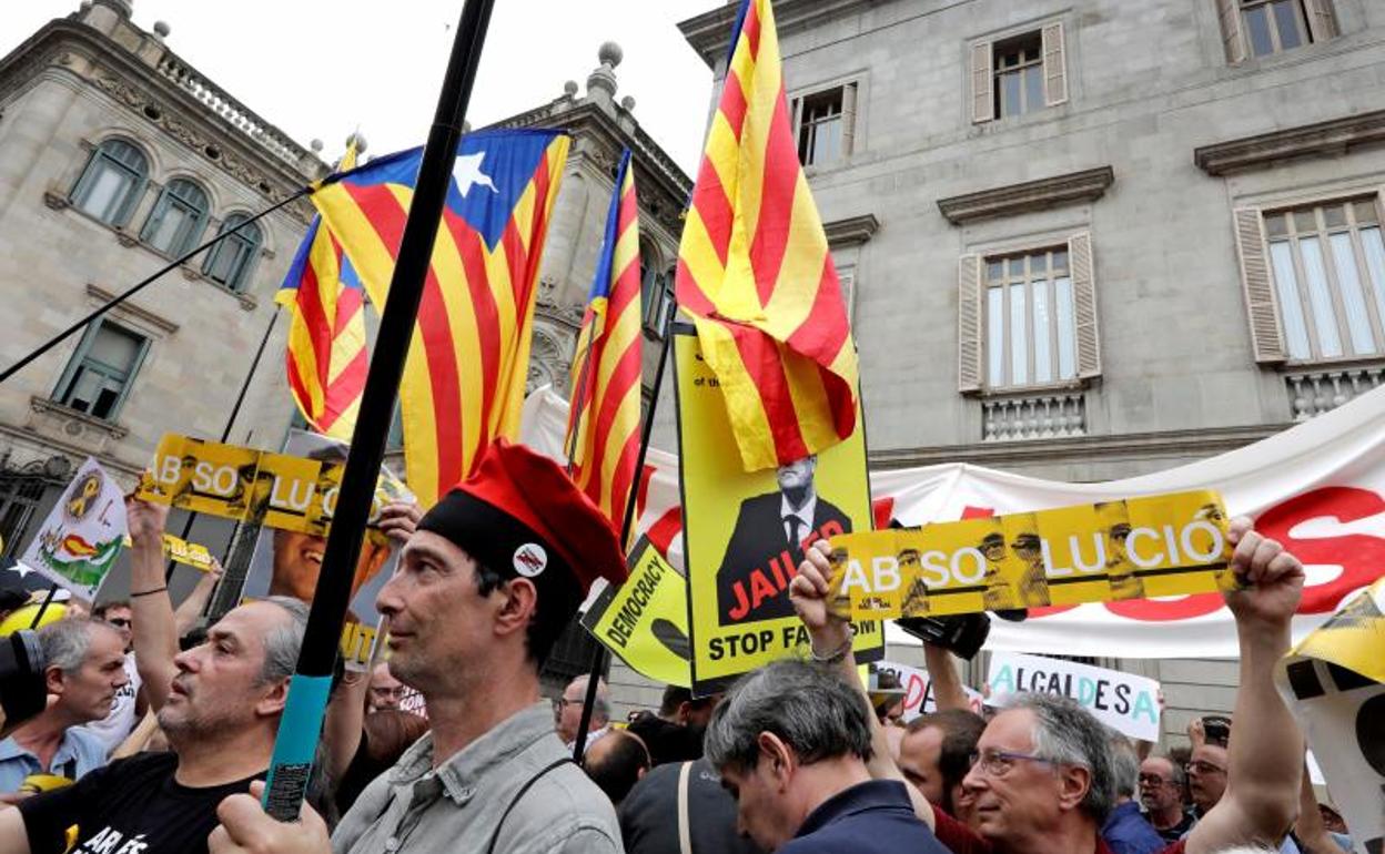 Concentración en la plaza Sant Jaume, donde manifestantes independentistas portan 'esteladas' y carteles con el rostro de los presos del 'procés' . 