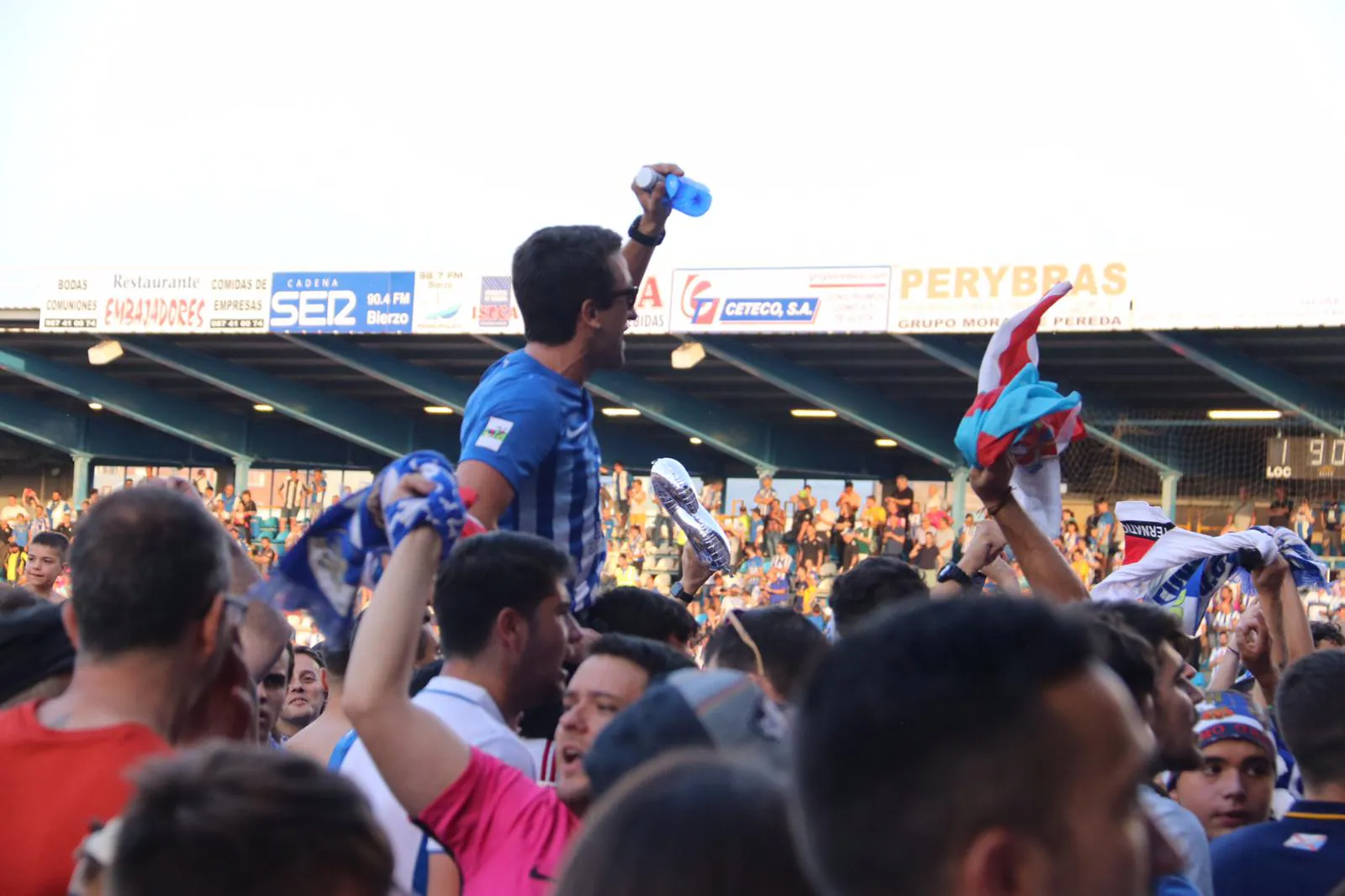 Los aficionados celebran el ascenso a Segunda División a pie de campo.