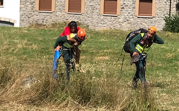 Los agentes del Greim trasladan a hombres a la montañera herida. 