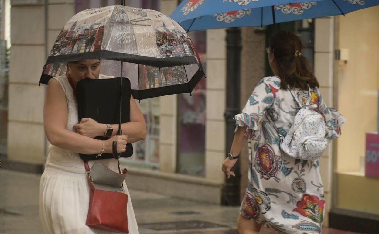 Una mujer se resguarda de la lluvia en Valladolid.