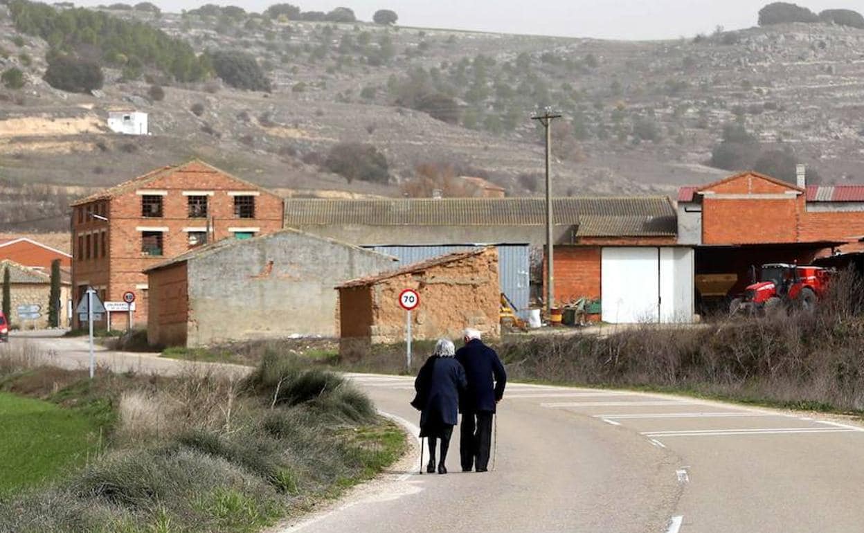 Pareja de personas mayores paseando por la carretera de Valdearcos de la Vega (Valladolid)