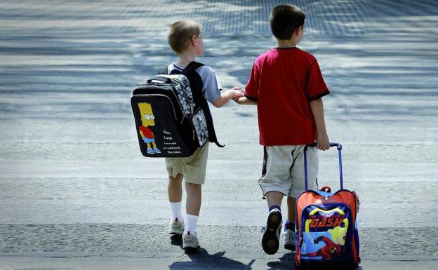 Niños cruzando un paso de cebra camino del colegio. 