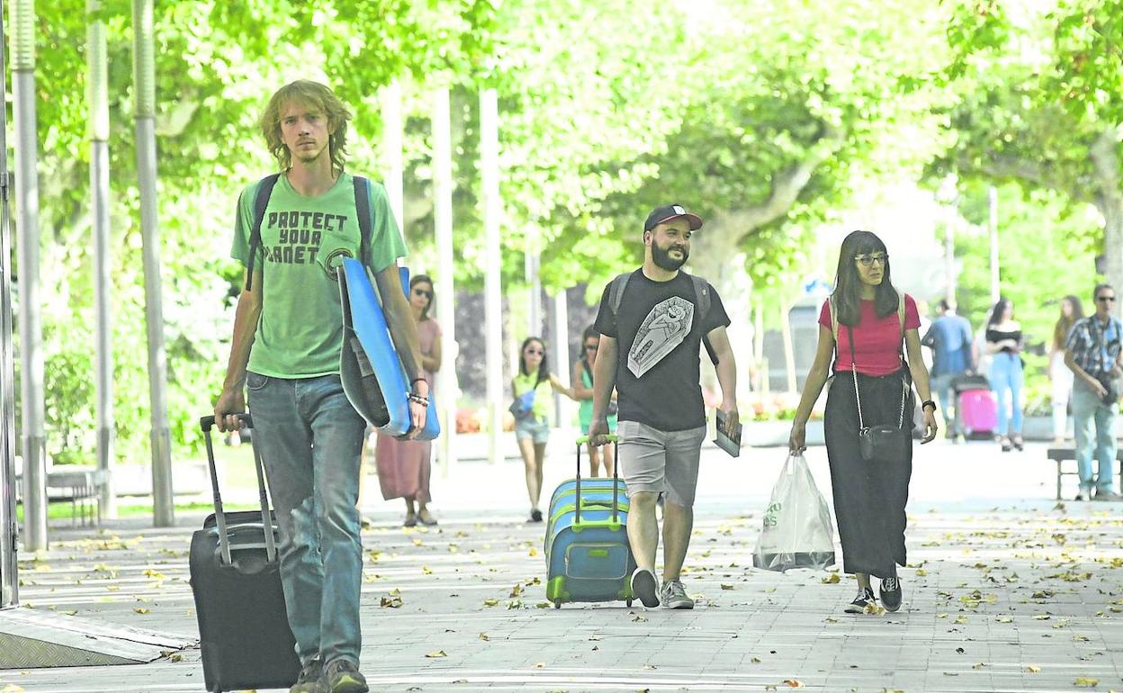 Turistas con sus maletas pasean por la Acera Recoletos de Valladolid.