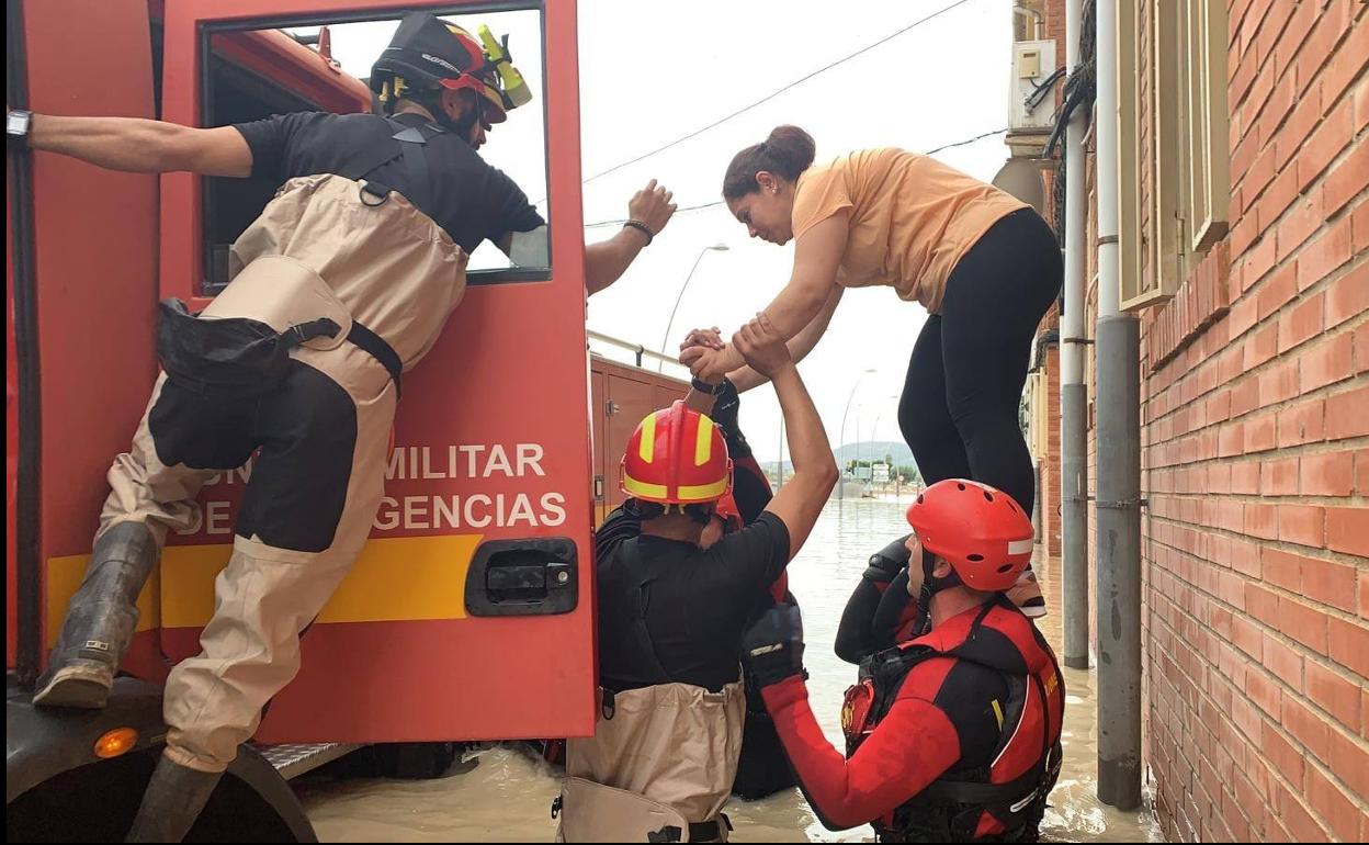 Efectivos de la UME socorren a una mujer en medio de la inundación. 