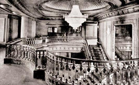 Imagen de la escalera y lámpara en el hall de entrada al teatro.