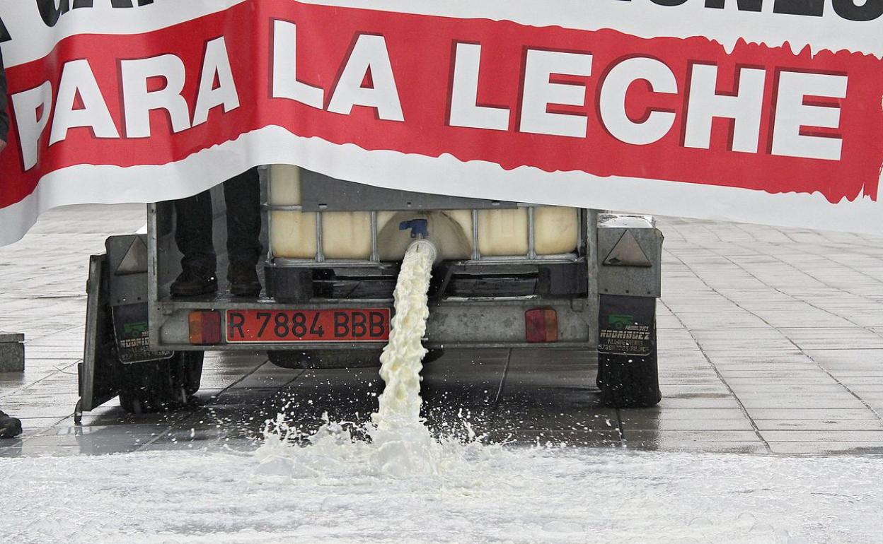 Ganaderos tirando leche durante una protesta en defensa del sector.