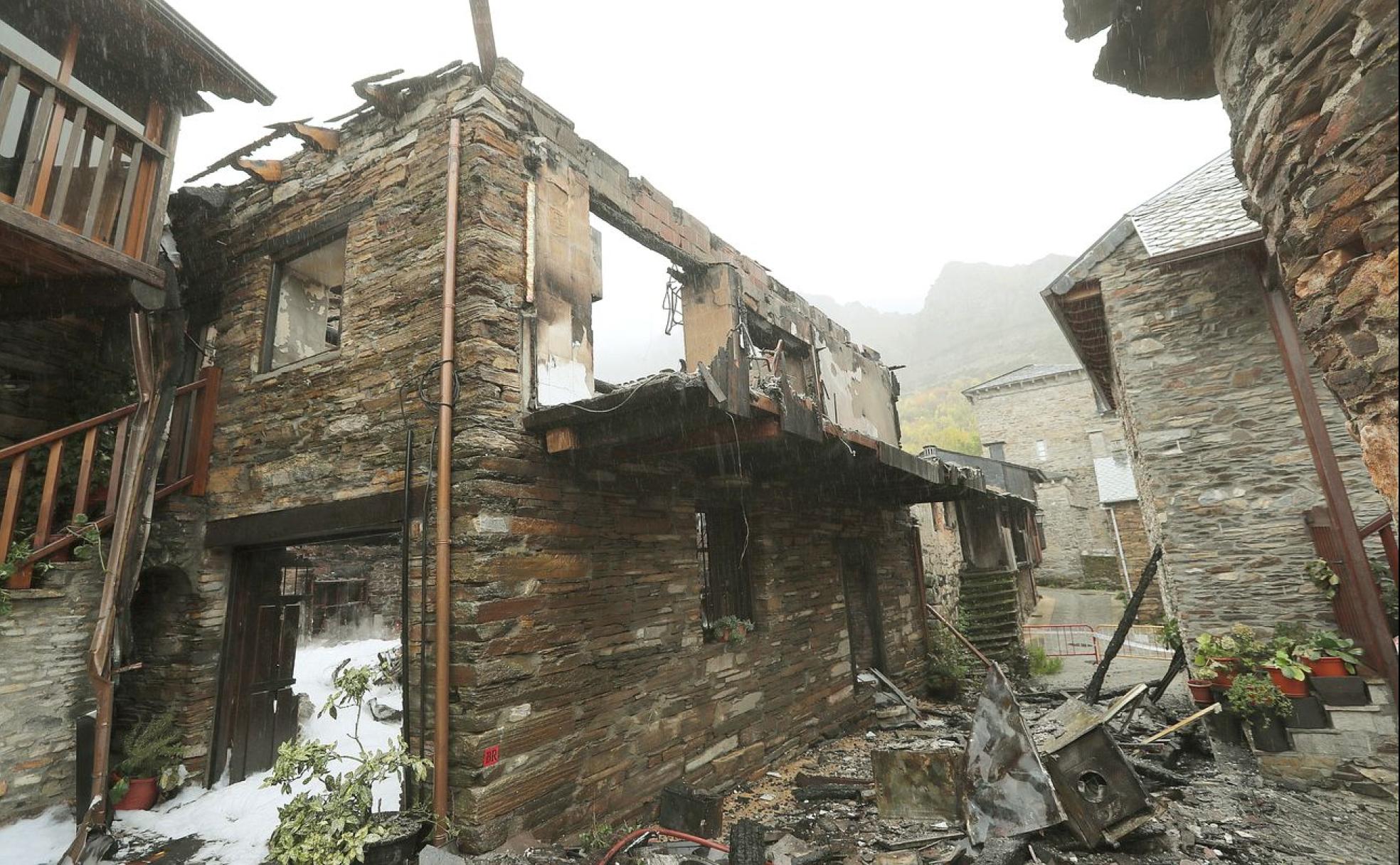 Restos de la vivienda calcinada, este jueves, bajo la lluvia.