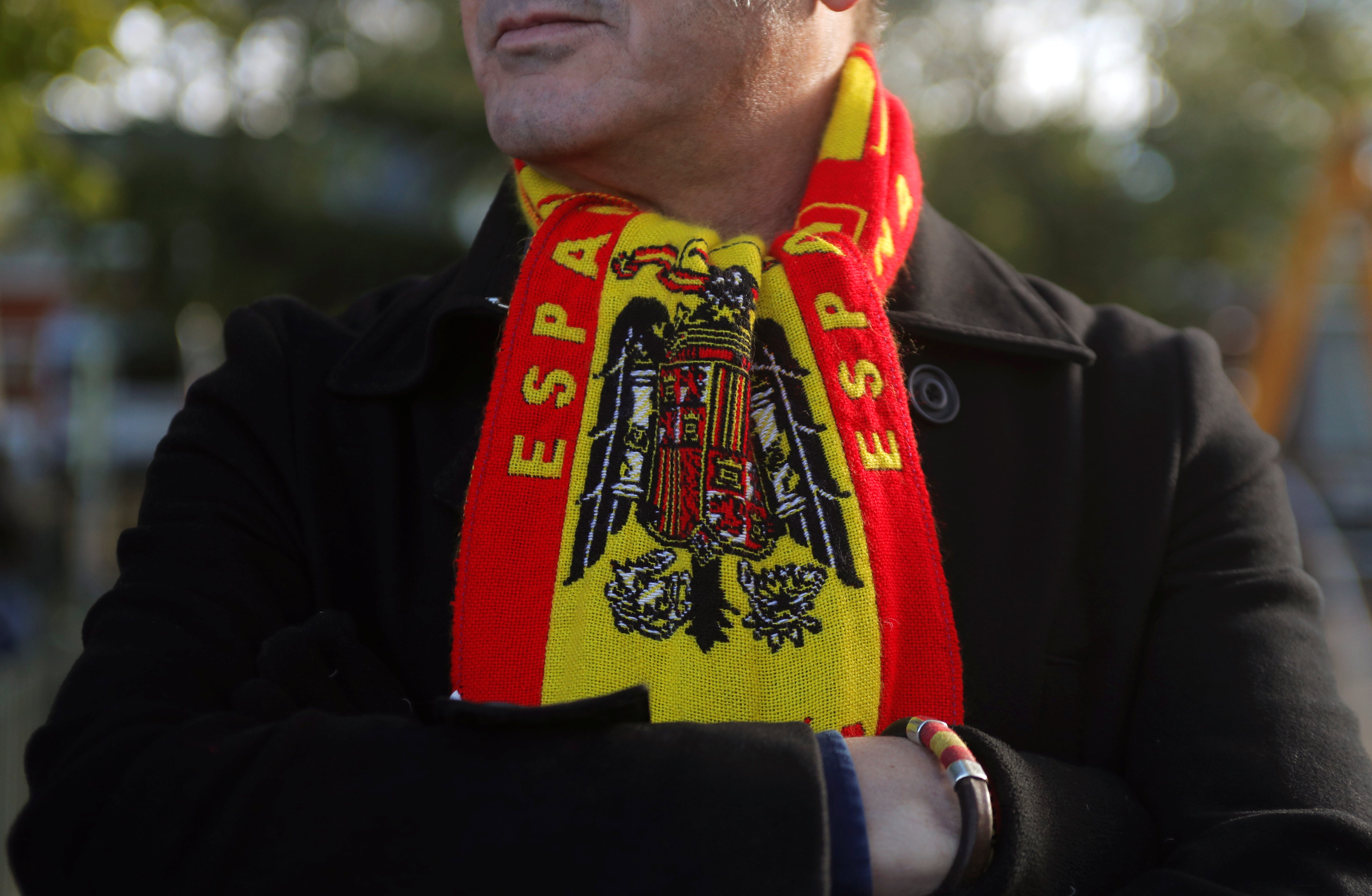 Un simpatizante de Franco se protege el cuello con una bufanda con la insignia de la bandera española de la época franquista.